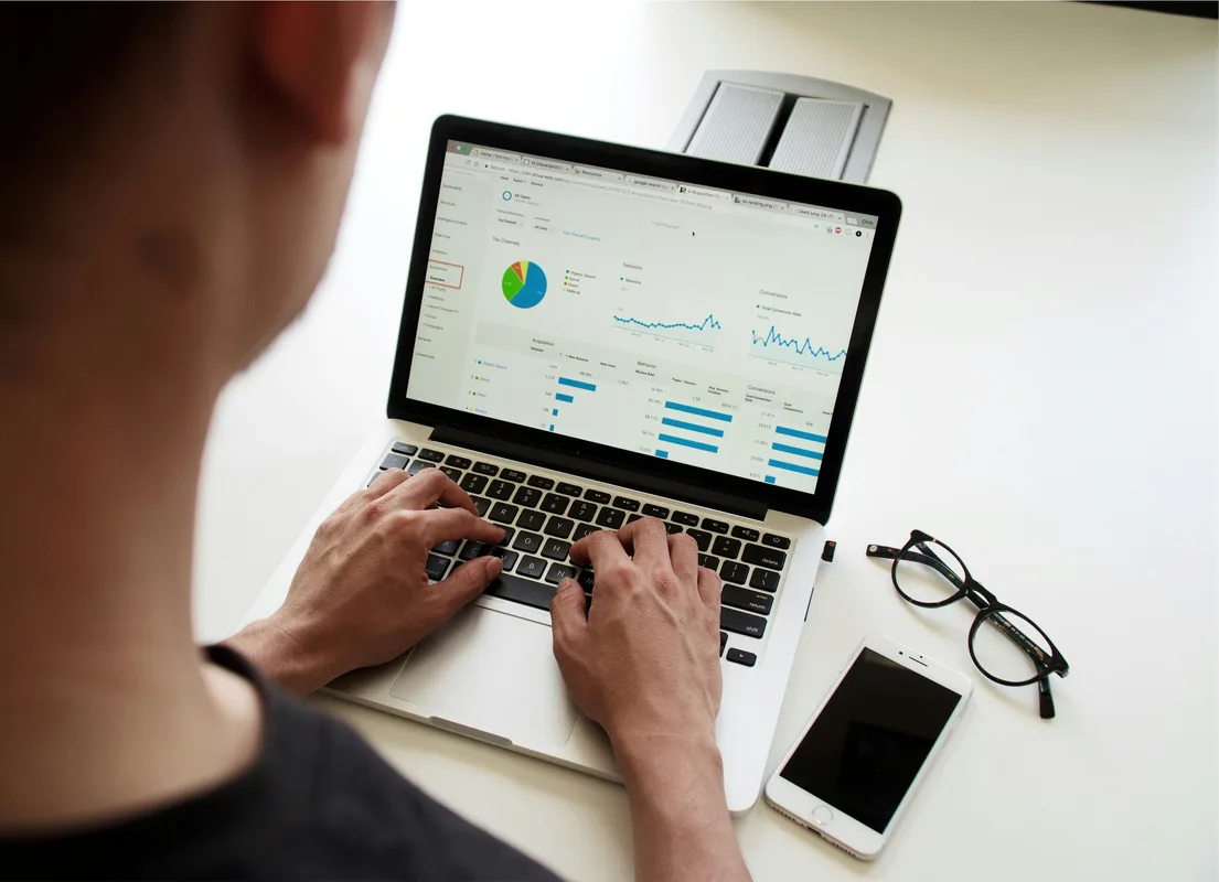 Business professional using a laptop dashboard to monitor digital performance and automated workflows.